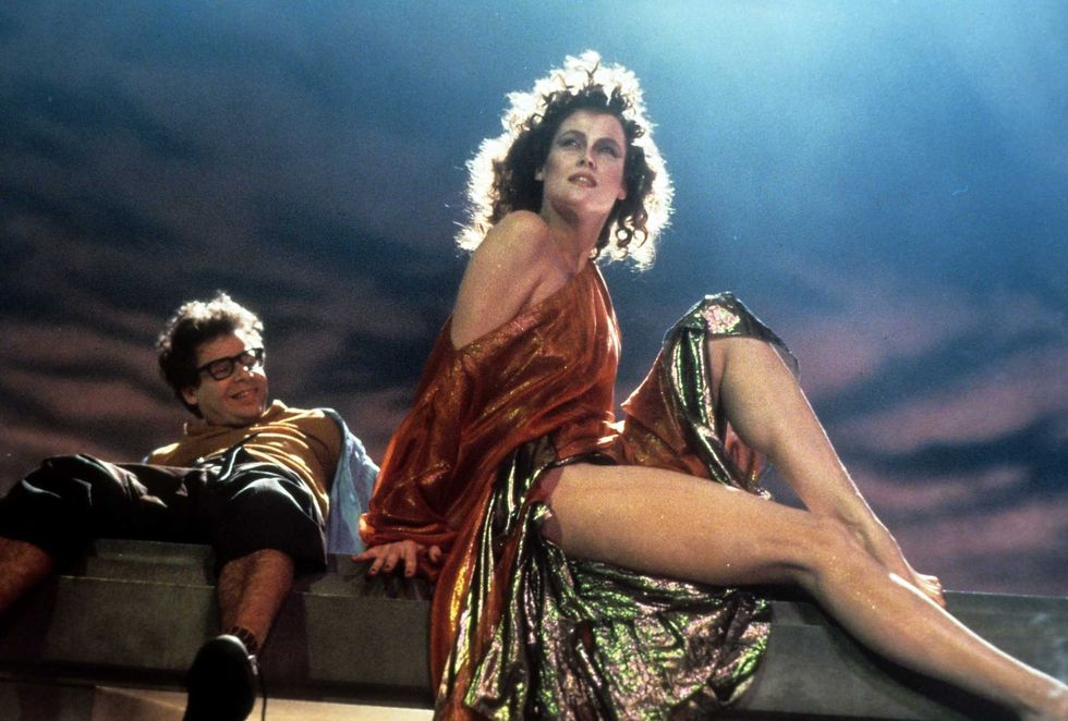 A smiling Rick Moranis looks up at Sigourney Weaver in a scene from the 1984 film "Ghostbusters"