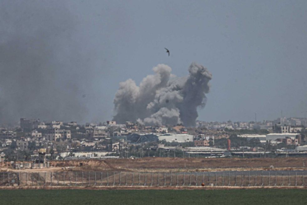 A smoke plume from an explosion in the Gaza Strip is seen from a position along Israel