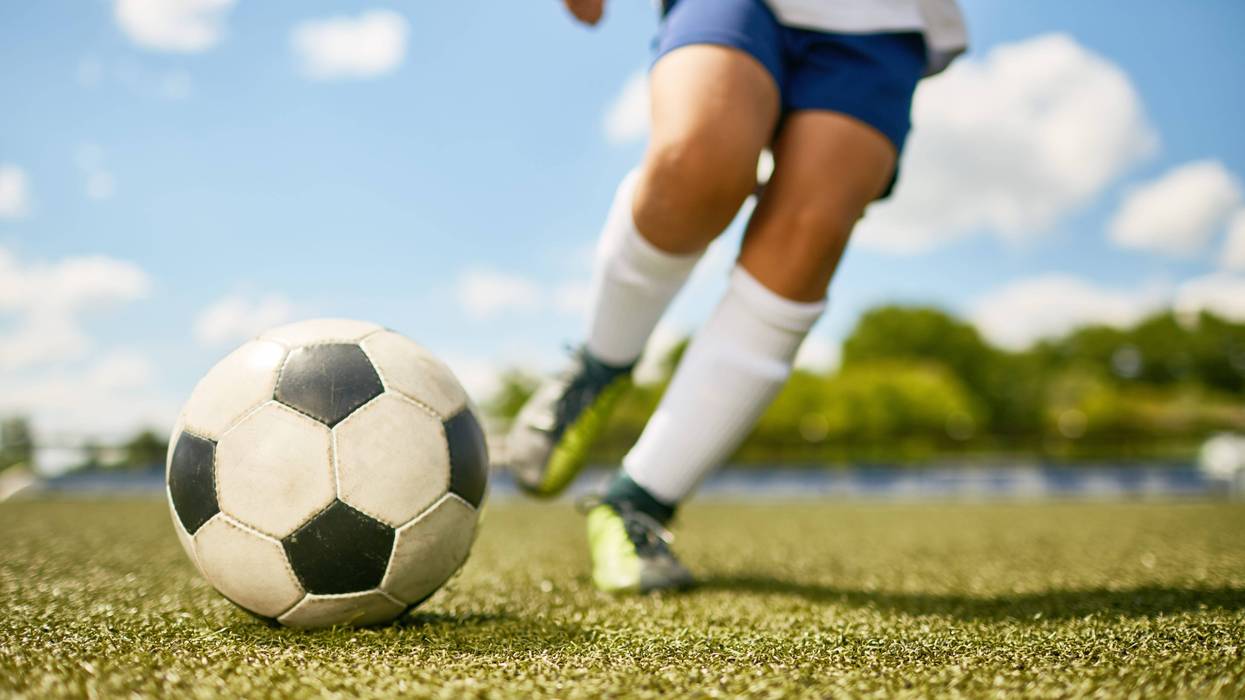 A soccer player about to kick a soccer ball.