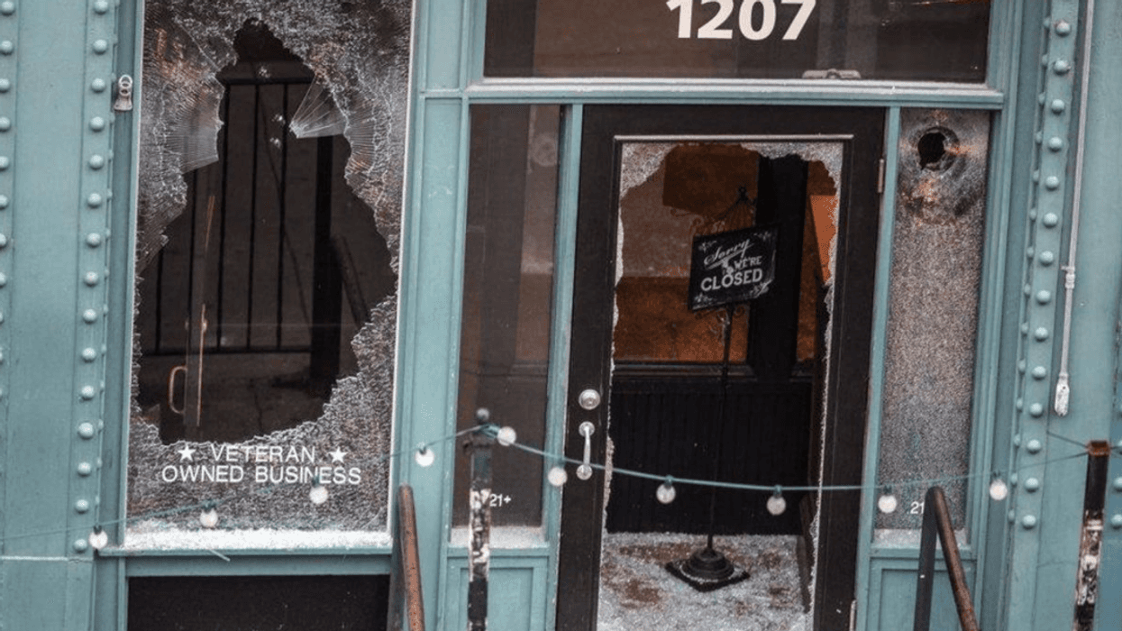 A "sorry we're closed" sign sits in the entrance surrounded by broken glass at The Hive, near where a man was shot to death during protests in May 20202. CHRIS MACHIAN/OMAHA WORLD-HERALD VIA AP