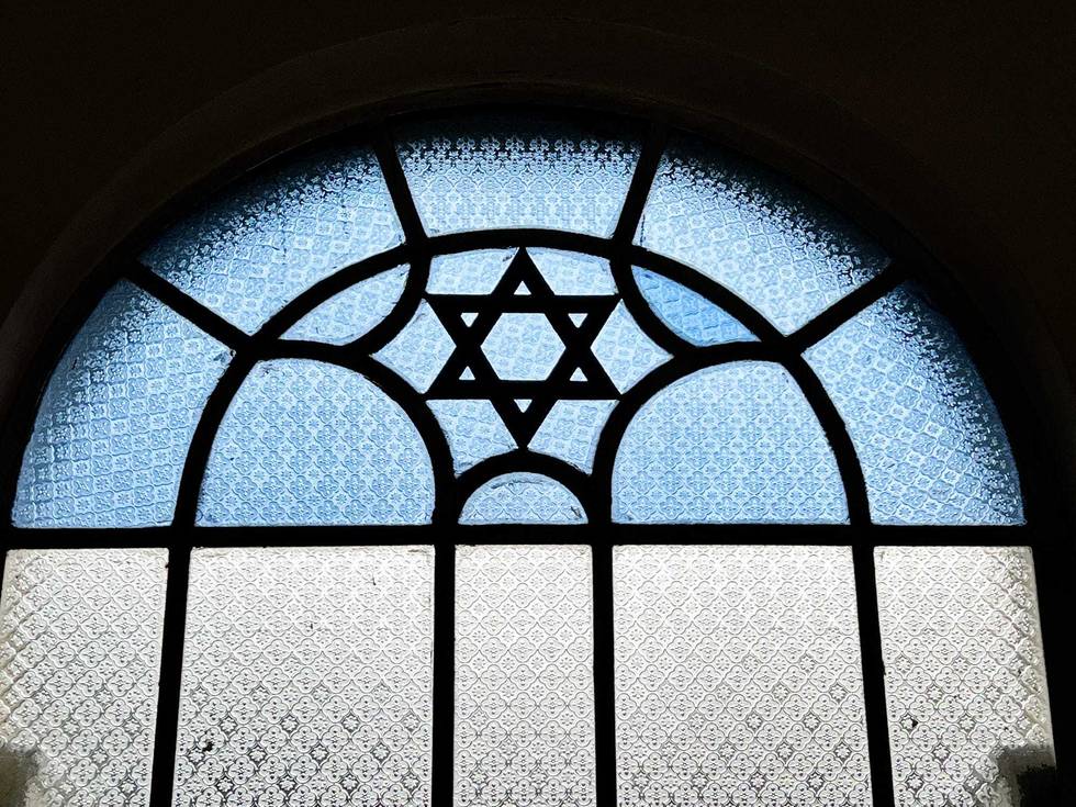 A stained glass window in a synagogue features a Star of David.
