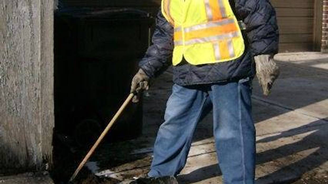 A Streets and Sanitation worker baits a rodent trap.