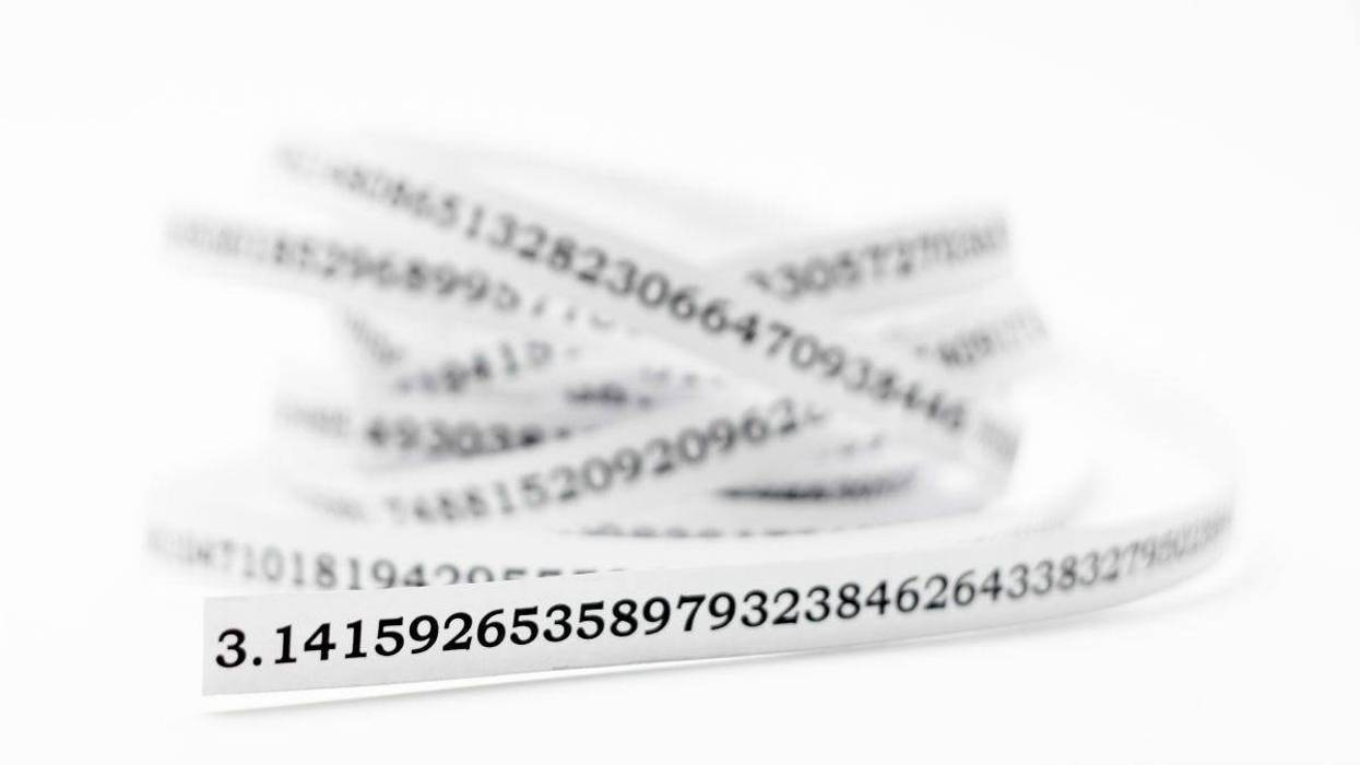 A string of a white paper with a written constant value of pi.