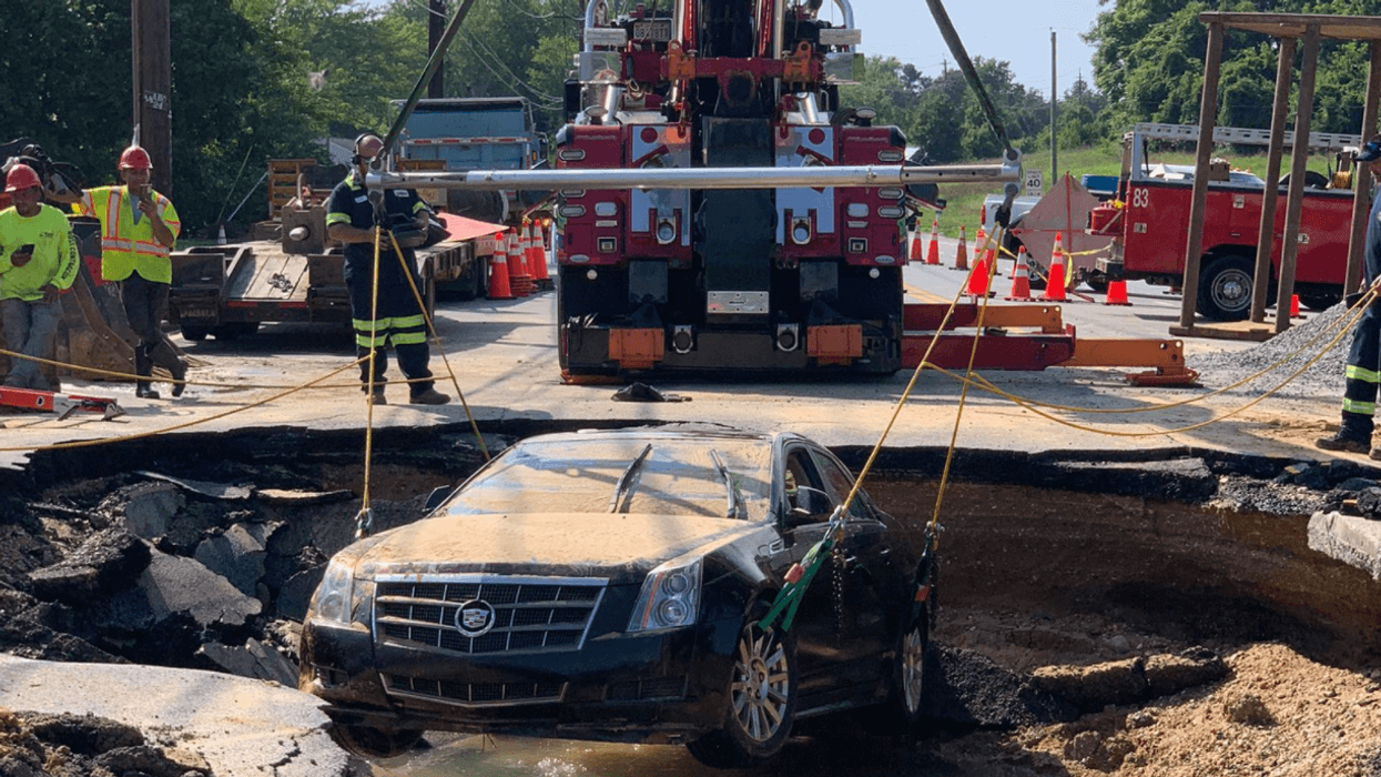 A submerged Cadillac is removed from 12-foot sinkhole.