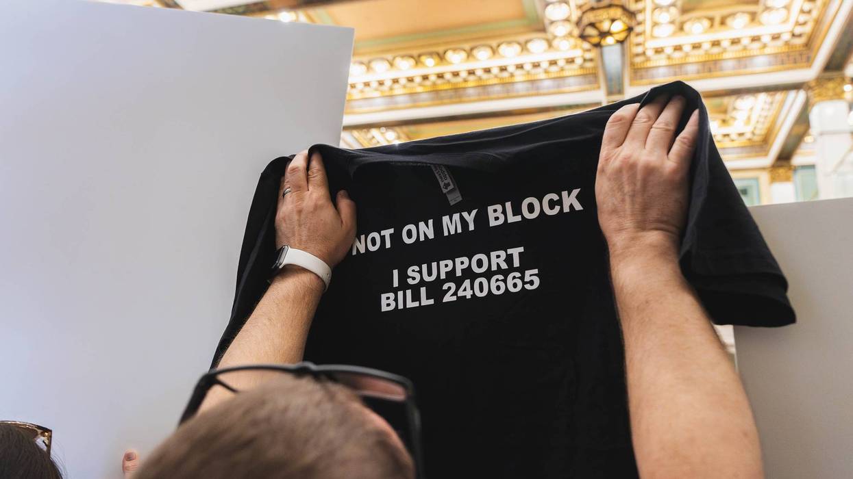 A supporter of the bill limiting mobile service providers holds up a shirt in City Council on Thursday, May 8, 2025.