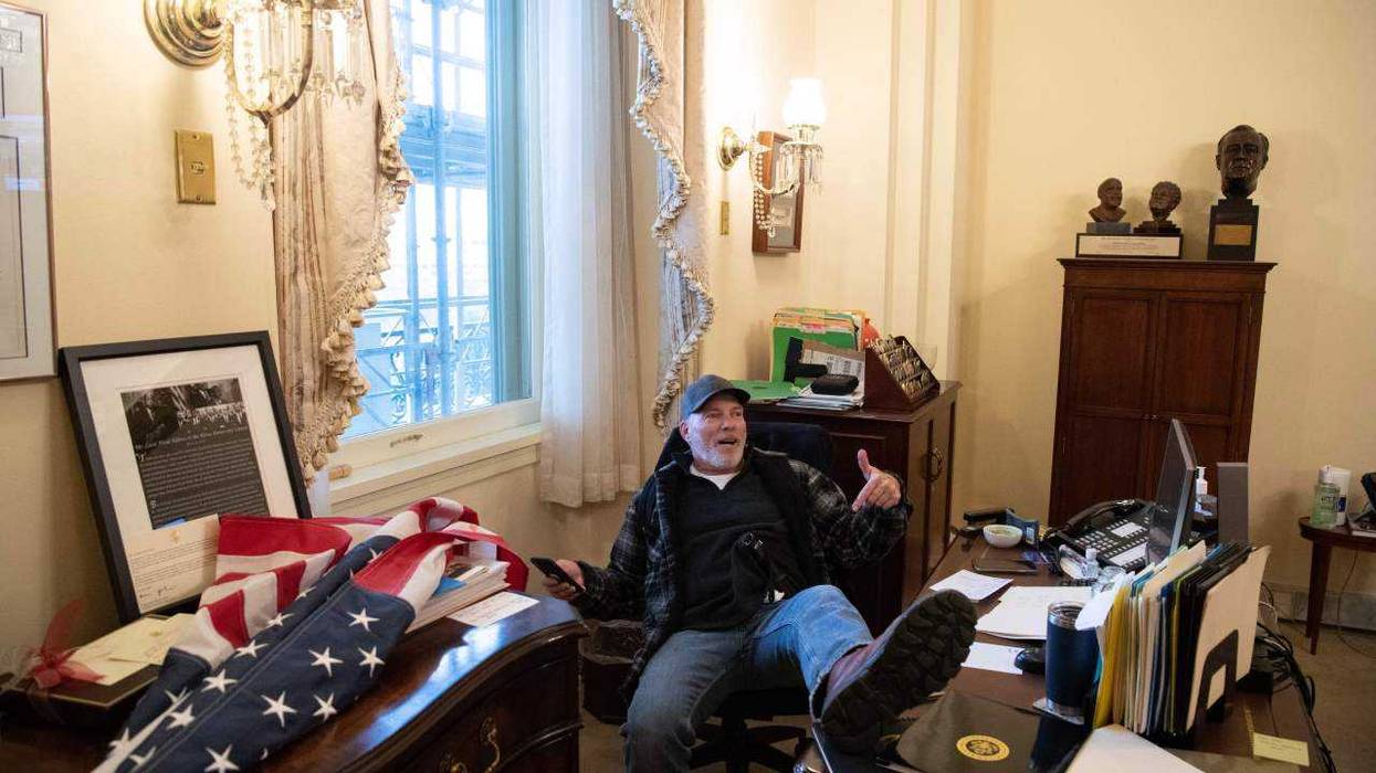 A supporter of US President Donald Trump sits inside the office of US Speaker of the House Nancy Pelosi as he protest inside the US Capitol in Washington, DC, January 6, 2021.