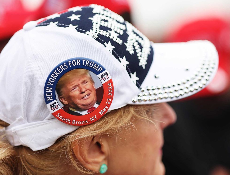 A supporter wears a "New Yorkers for Trump" button outside Nassau Coliseum