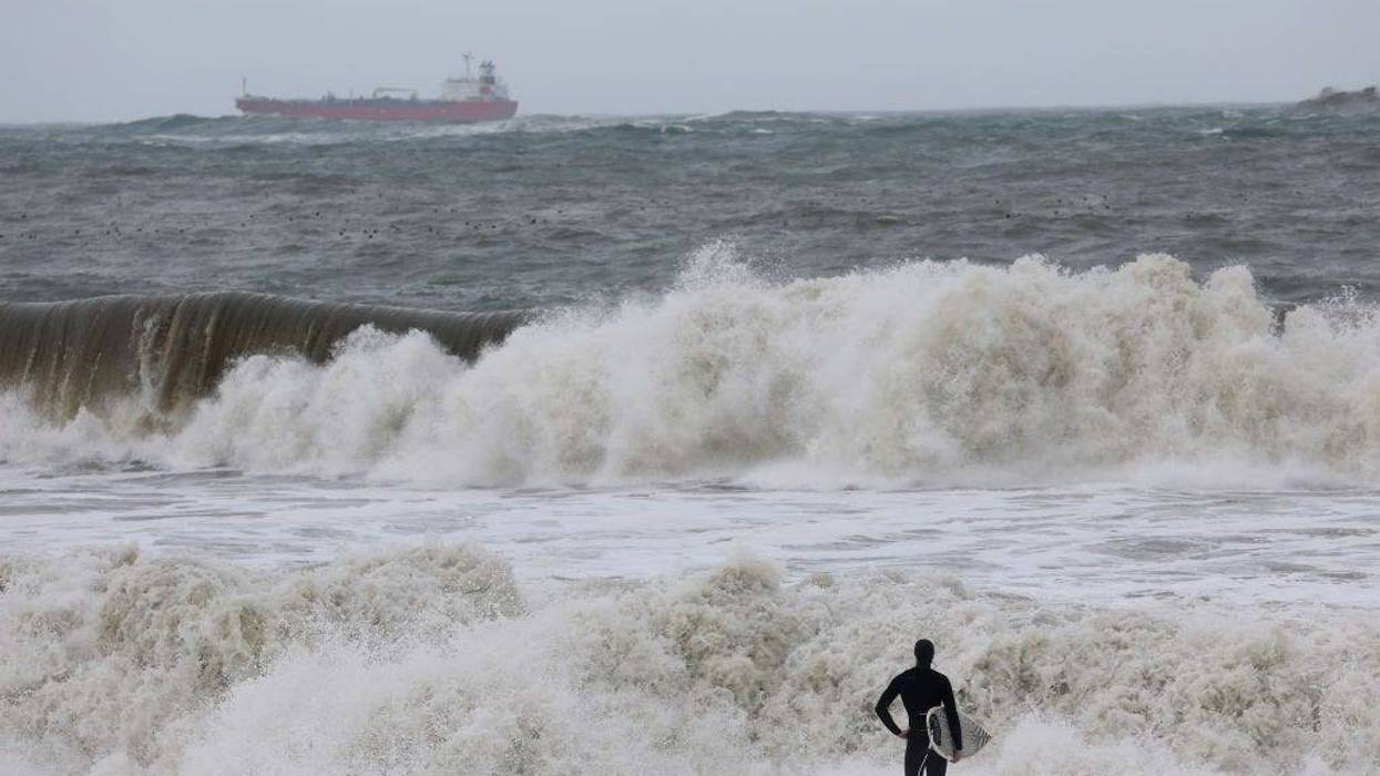 A surfer looks out at rough surf as a storm comes in Rodeo Beach on January 07, 2023 in Sausalito, California.