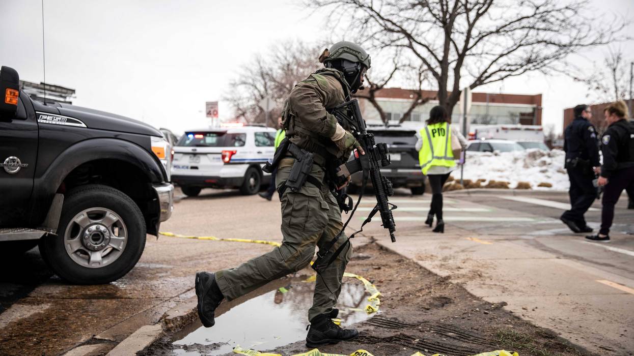 A SWAT team member runs toward a King Soopers grocery store where a gunman opened fire on March 22, 2021 in Boulder, Colorado.