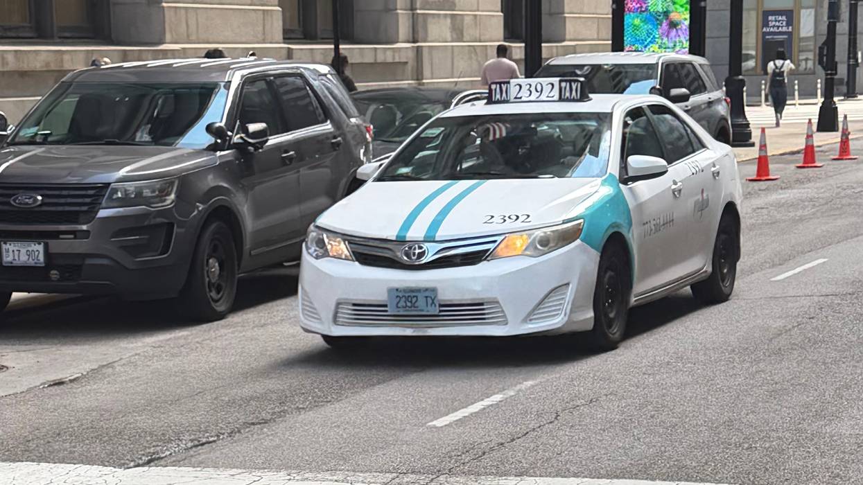 A taxicab drives by Chicago City Hall, April 14, 2026.