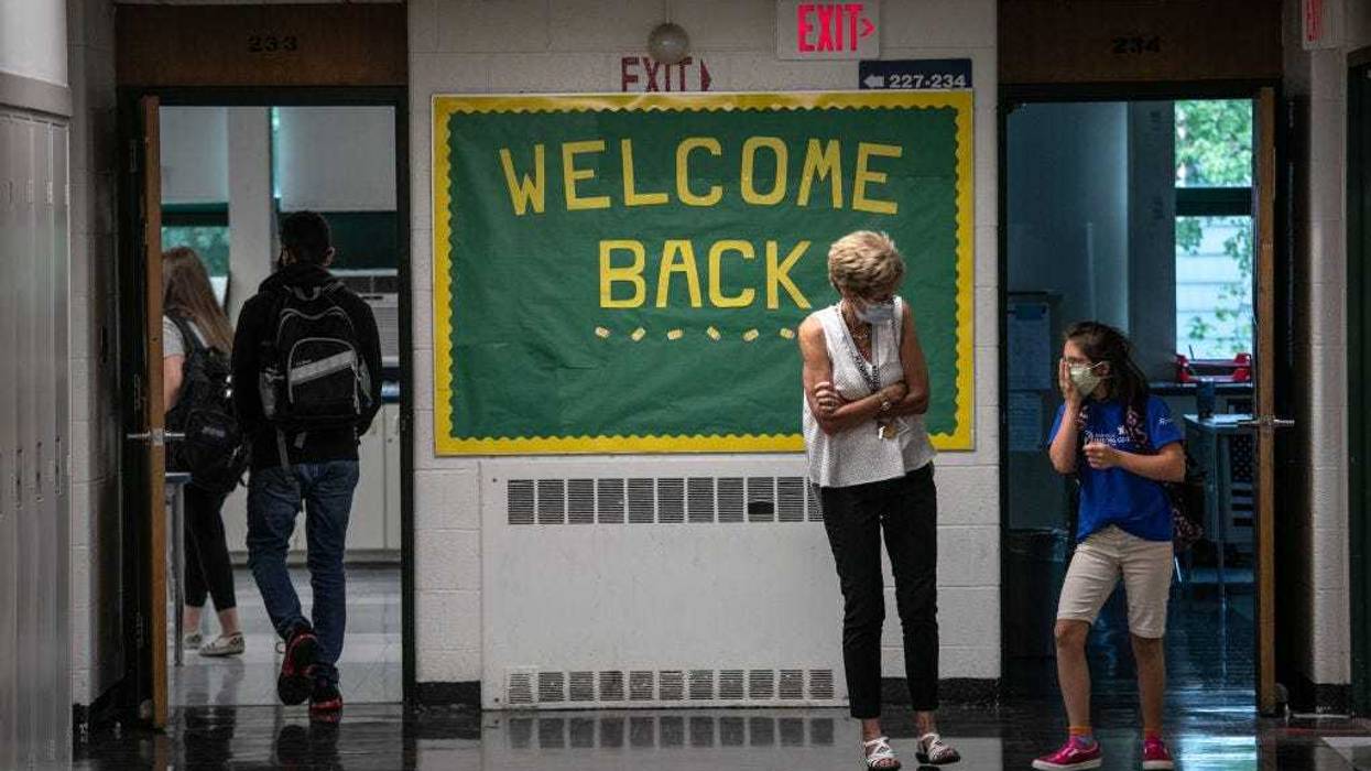 A teacher speaks with a student between classes at Rippowam Middle School on September 14, 2020 in Stamford, Connecticut. Most students at the middle school are taking part in a hybrid model, where they attend in-school classes every other day and distance learn the rest. More than 20 percent of students in the Stamford Public Schools district are enrolled in the distance learning option only, due to coronavirus concerns.