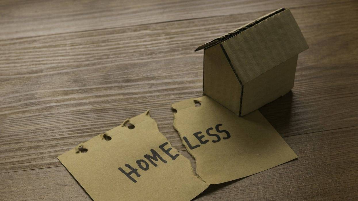A tear paper written with Homeless and cardboard house - stock photo
