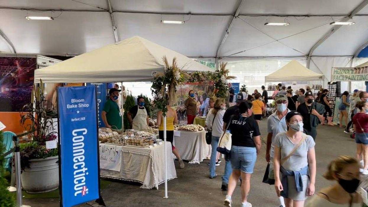 A tent adjacent to the Connecticut building at the Big E fair, promoting various businesses in the state.