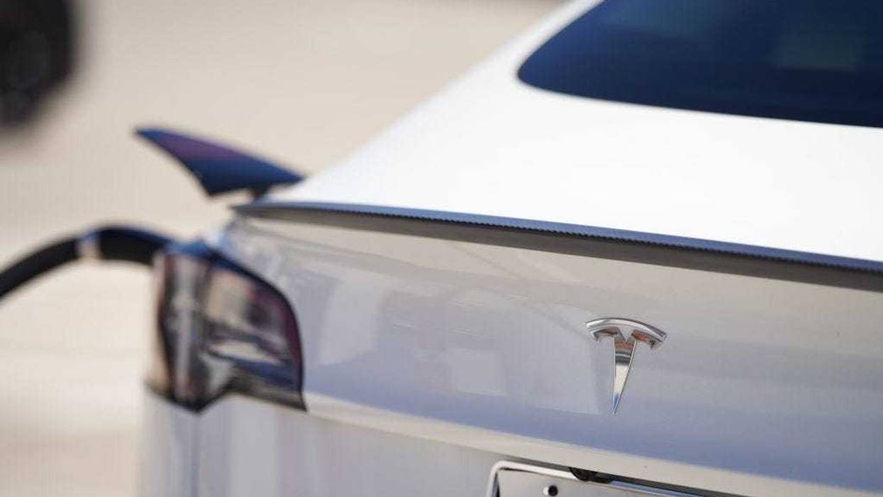 A Tesla vehicle is plugged into a Tesla charging station in a parking lot on September 22, 2022 in Santa Monica, California.