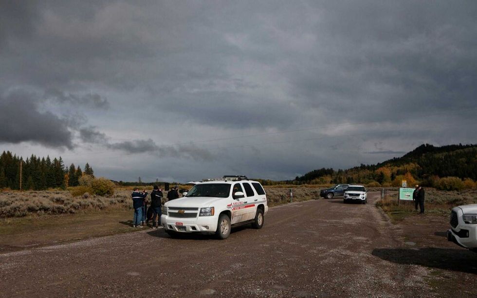 A Teton County Search & Rescue vehicle drives past members of the media, left, gathered at a road blocked by U.S. Park Ranger vehicles in the Spread Creek area of the Bridger-Teton National Forest, just east of Grand Teton National Park off U.S. Highway 89, in Wyoming, Sunday, Sept. 19, 2021