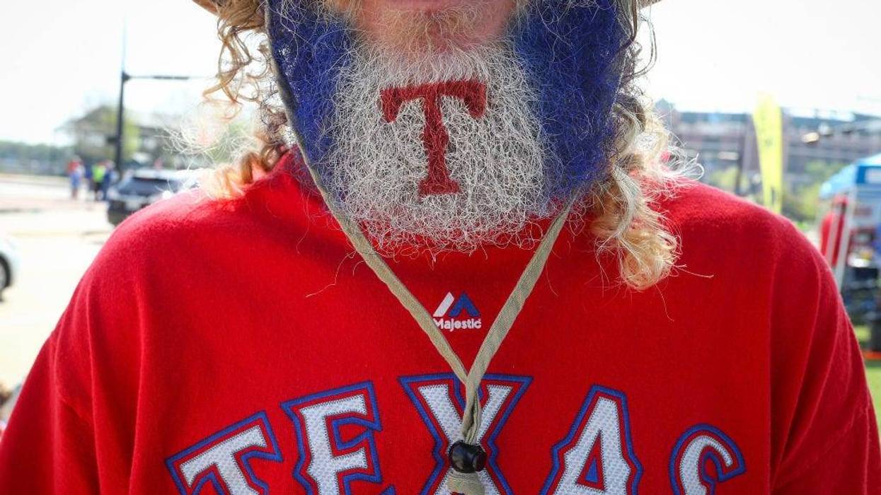 A Texas Rangers fan makes his way to the ballpark with his beard decorated with the team's logo before the Opening Day game against the Houston Astros at Globe Life Park in Arlington on March 29, 2018 in Arlington, Texas.