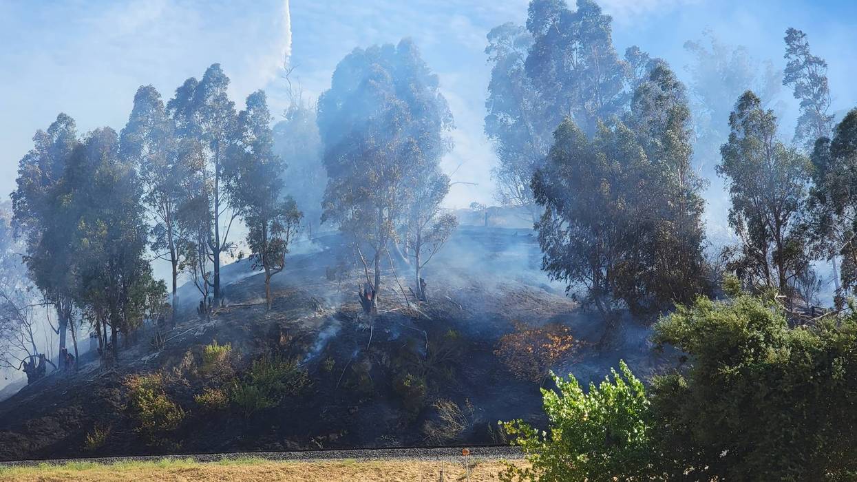 A three-alarm fire is burning in the East Bay, threatening homes and putting up smoke.