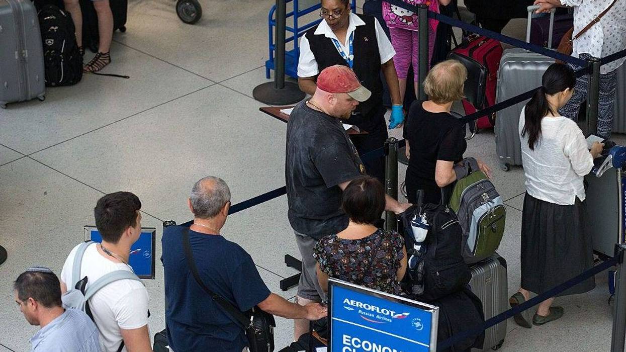 A Transportation Security Administration employee checks passenger tickets