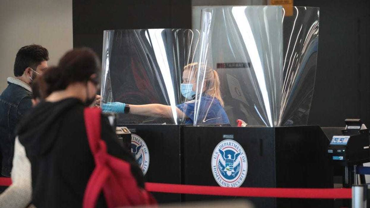 A Transportation Security Administration (TSA) agent screens an airline passenger at O'Hare International Airport on October 19, 2020 in Chicago, Illinois. Yesterday the TSA reported that it had screened over 1 million passengers, representing the highest number of passengers screened at TSA checkpoints since March 17, 2020. During the week ending October 18, TSA screened 6.1 million passengers nationwide, the highest total since the start of the COVID-19 pandemic. (Photo by Scott Olson/Getty Images)
