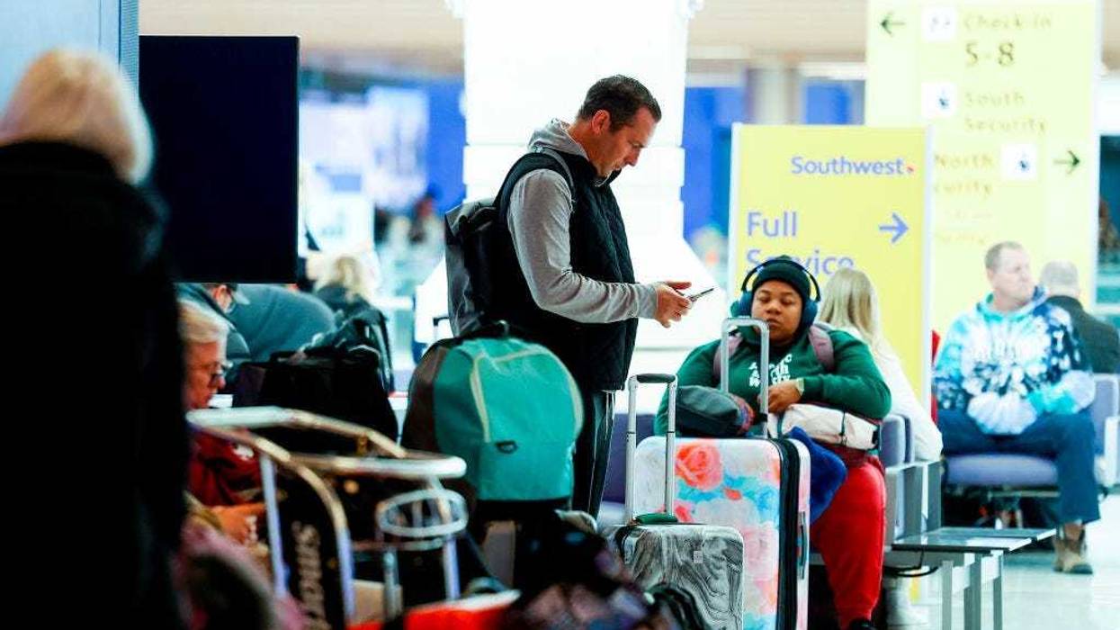 A traveler checks his phone during a winter storm at Denver International Airport on February 22, 2023 in Denver, Colorado. More than 1000 flights have been canceled across the U.S. as the storm impacts travel around the country. (Photo by Michael Ciaglo/Getty Images)