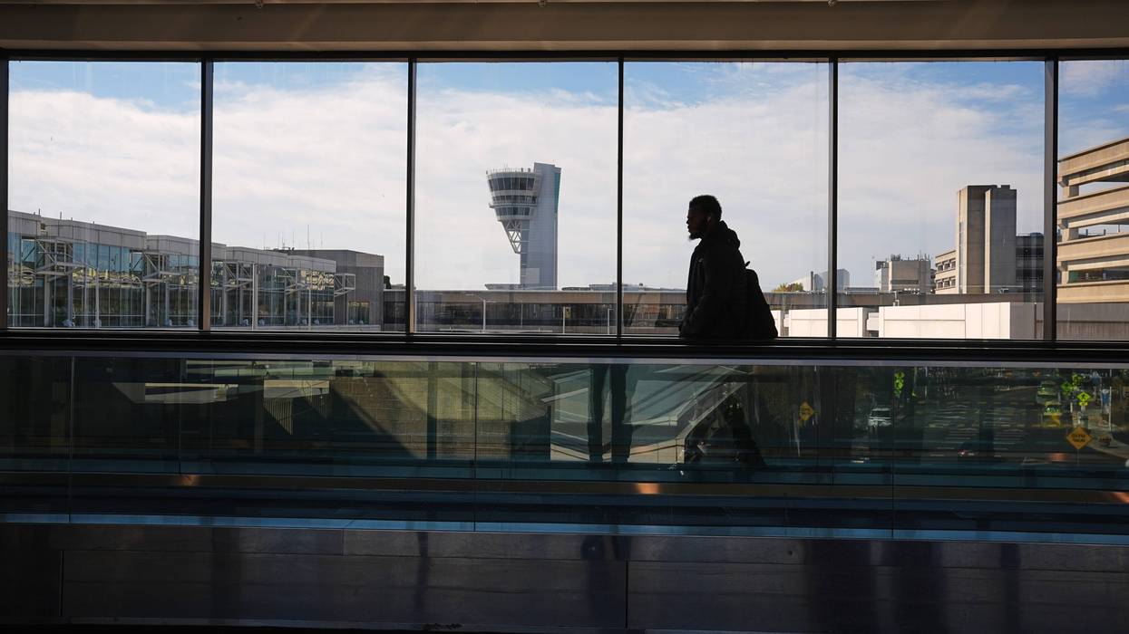 A traveler moves in view of a control tower at Philadelphia International Airport in Philadelphia, Nov. 5, 2025.