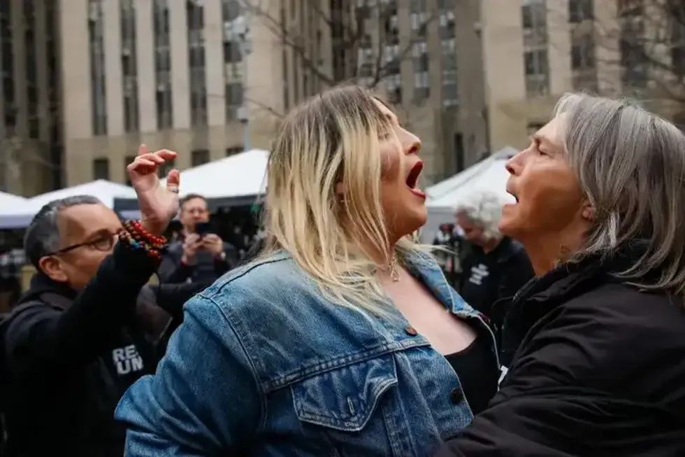 A Trump supporter (L) argues with an anti-Trump protester (R) after she removed an anti-Trump banner outside Manhattan Criminal Court on April 4, 2023.