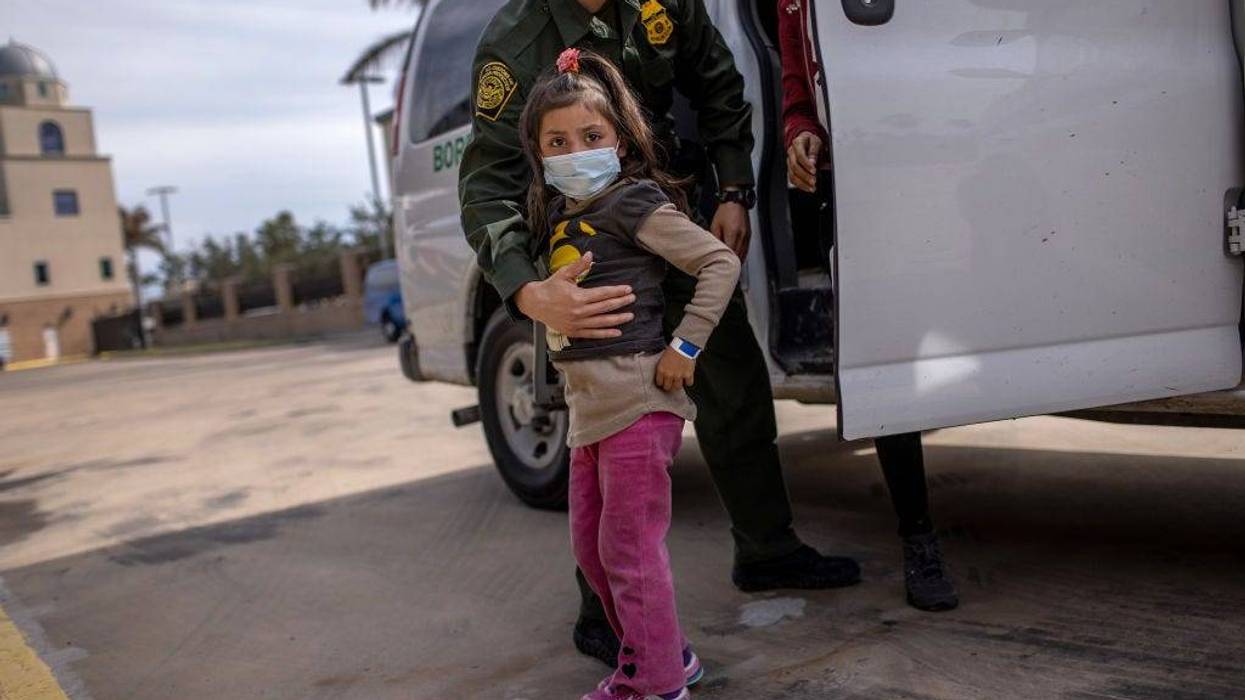 A U.S. Border Patrol agent delivers a young asylum seeker