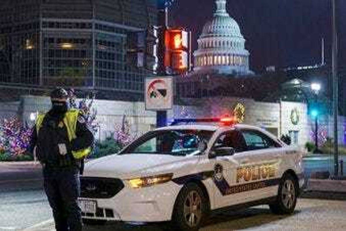 A U.S. Capitol Police officer stands watch on Independence Avenue before dawn as the House and Senate prepare to convene a joint session to count the electoral votes cast in November's election. (AP Photo/J. Scott Applewhite)