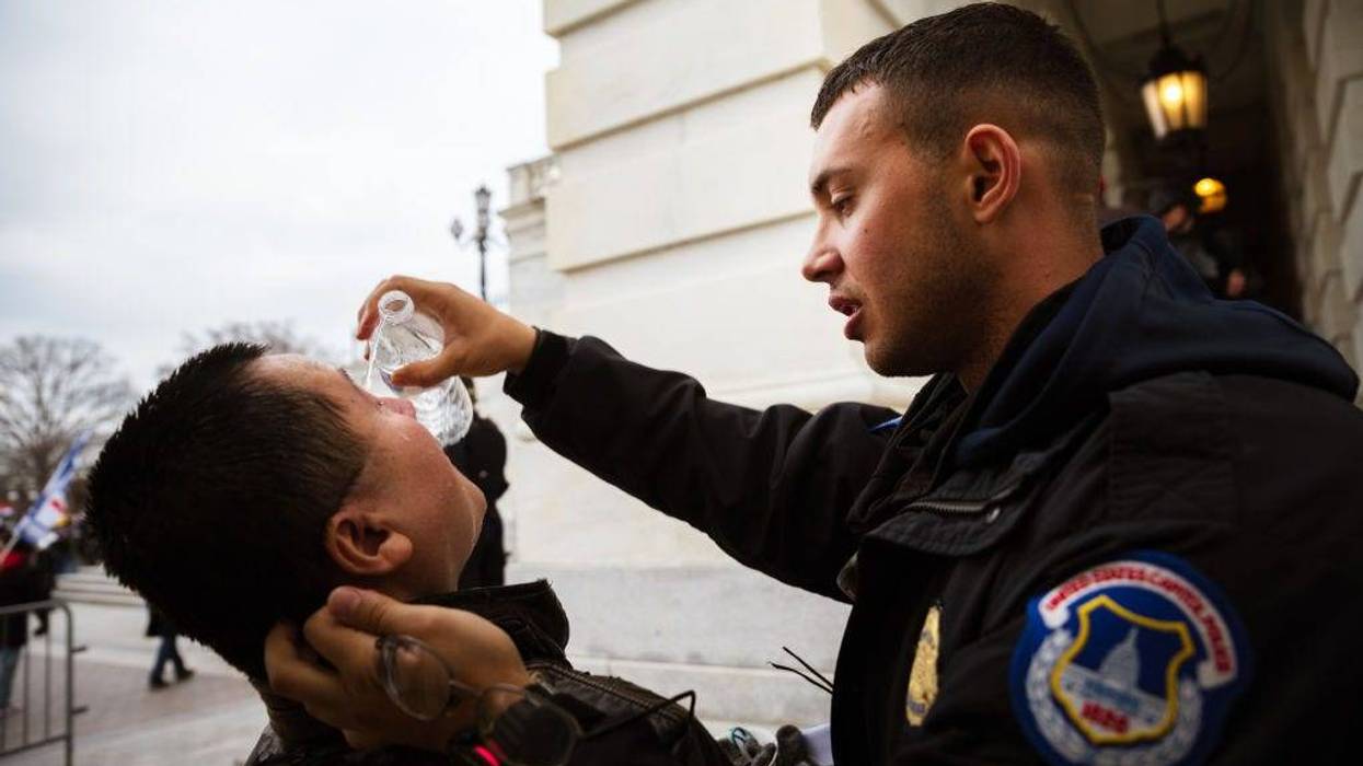 A U.S. Capitol Police officer tends to a Trump supporter suffering the effects of chemical agents used to disperse a mob that stormed the Capitol on Jan. 6, 2021, to stop Congress from certifying Joe Biden's Electoral College victory over Donald Trump.