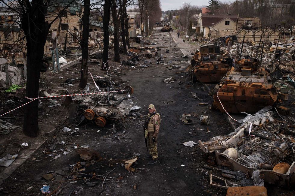 A Ukrainian serviceman stands amid destroyed Russian tanks in Bucha, on the outskirts of Kyiv, Ukraine, Wednesday, April 6, 2022