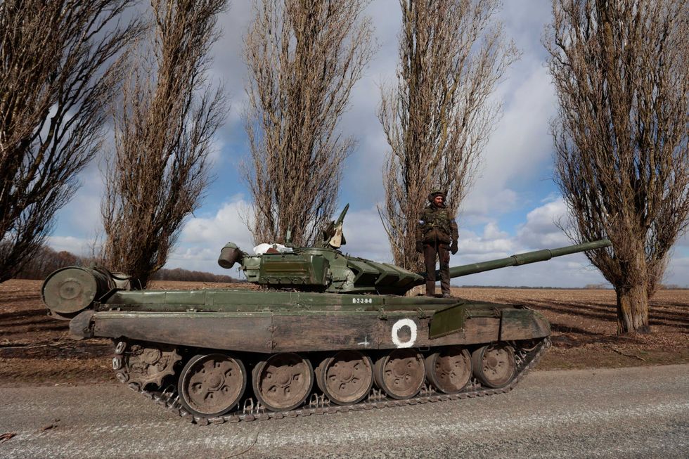 A Ukrainian serviceman stands on a tank in the village of Lukyanivka, Kyiv region, Ukraine, Monday, March 27, 2022