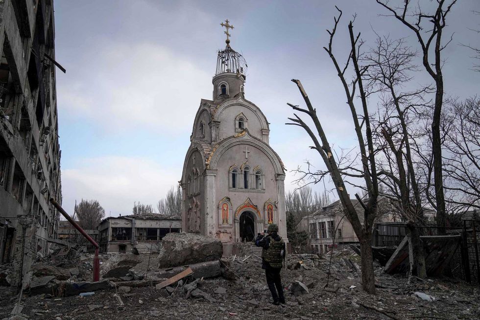 A Ukrainian serviceman takes a photograph of a damaged church after shelling in a residential district in Mariupol, Ukraine, Thursday, March 10, 2022