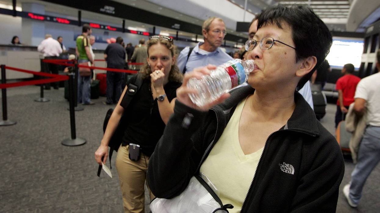 A United Airlines passenger takes a sip of water before throwing away the bottle at a security checkpoint at San Francisco International Airport August 10, 2006 in San Francisco.