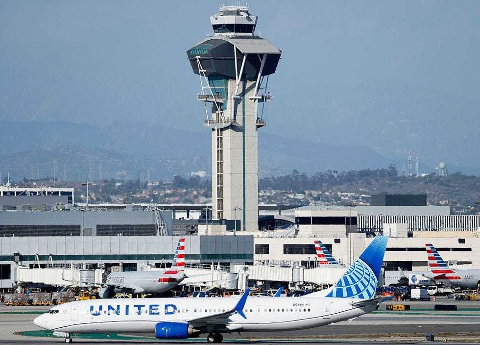 A United plane taxis in front of the air traffic control tower at Los Angeles International Airport on October 22, 2025 in Los Angeles, California. The Secretary of Transportation stated yesterday that air traffic controllers could stop receiving a paycheck next week while the federal government shutdown continues.