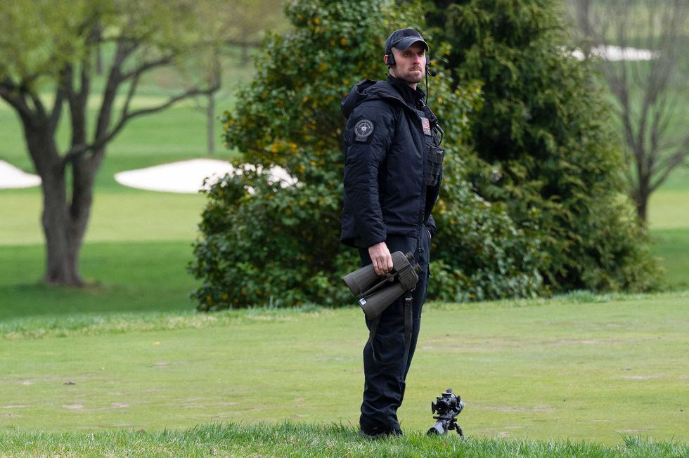A US Secret Service sniper watches the course as US President Joe Biden plays a round of golf at Wilmington Country Club in Wilmington, Delaware on April 17, 2021. - President Joe Biden played golf for the first time in his presidency Saturday, hitting the fairways in his home city of Wilmington