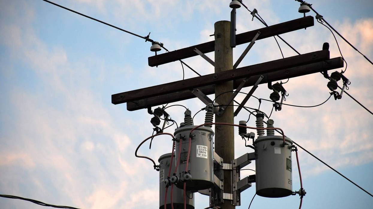 A utility pole sits against a blue and pink sunset sky.