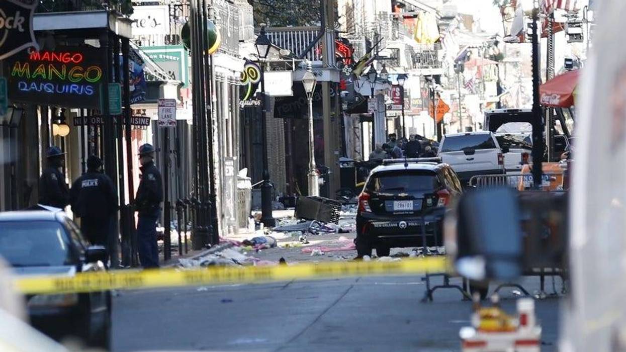 A view down Bourbon Street showing a crashed white pickup truck (R) after an apparent attack during New Year's Eve celebrations in New Orleans.
