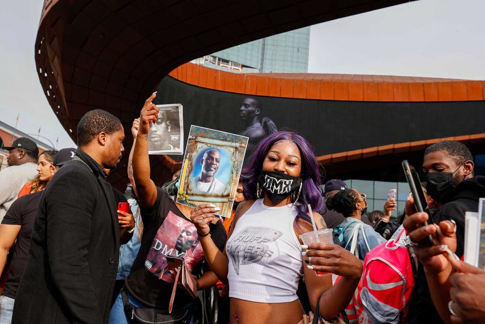 A view of the crowd as a mourner poses with an image honoring DMX, during the Memorial Service Held For Rapper DMX at Barclays Center on April 24, 2021 in New York City.