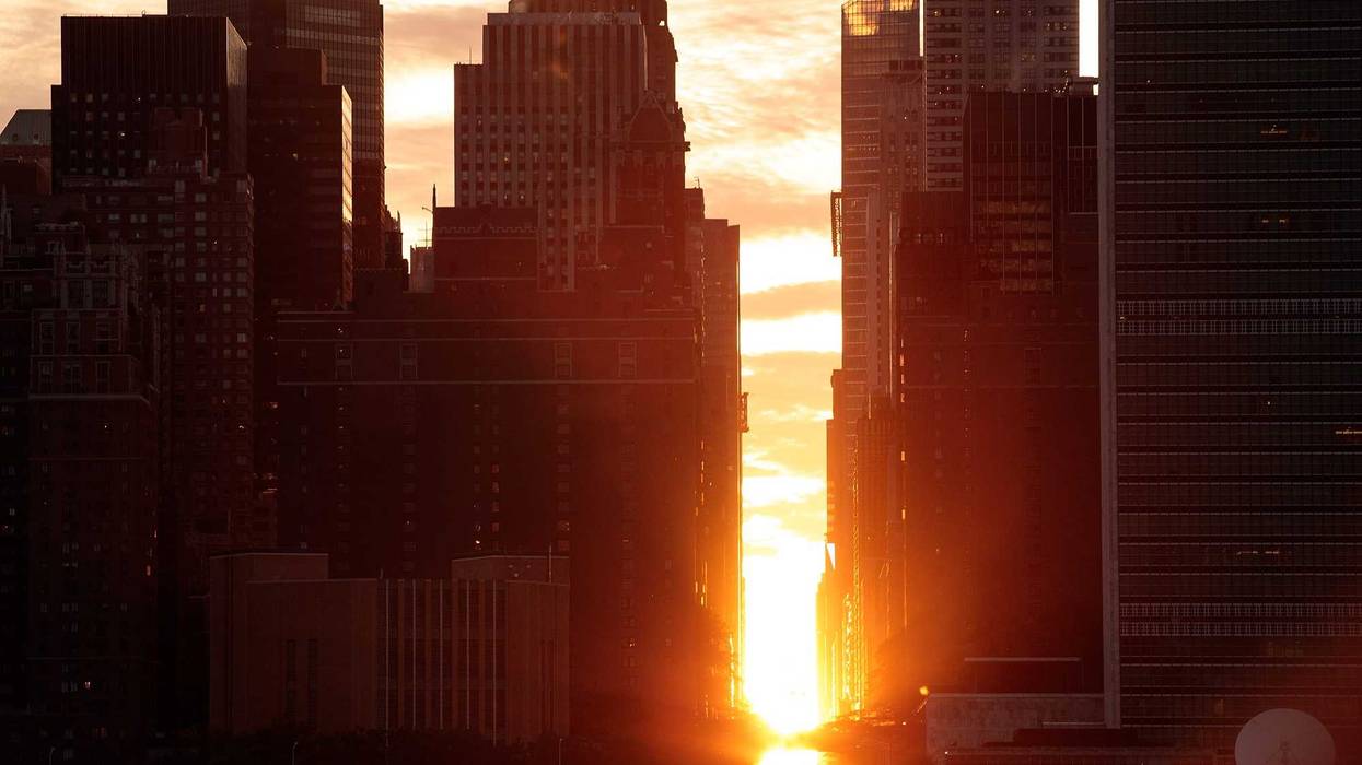 A view of the 'Manhattanhenge' sunset from Hunters Point South Park, July 11, 2016 in the Queens borough of New York City. 'Manhattanhenge' is created when the setting sun aligns with the city's street grid.