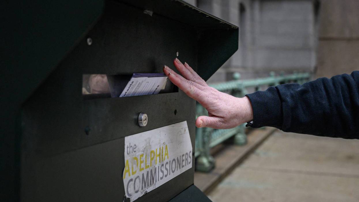 A voter casts a ballot at a drop box standing outside Philadelphia City Hall.