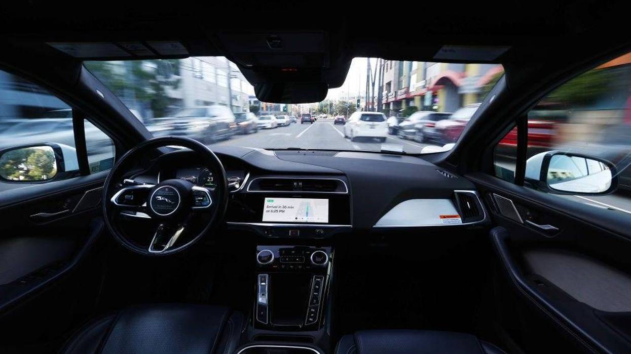 A Waymo autonomous self-driving Jaguar taxi drives along a street on March 14, 2024 in Los Angeles, California.