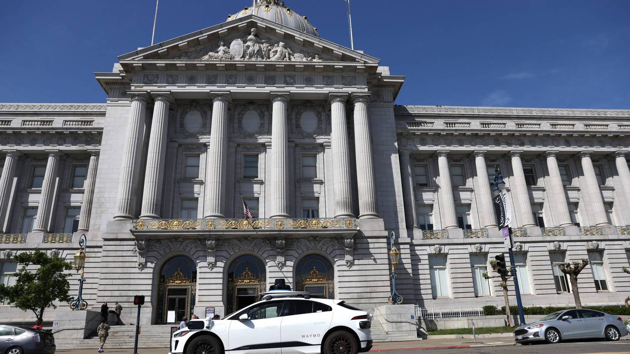 A Waymo autonomous vehicle drives by San Francisco City Hall on April 11, 2022 in San Francisco, California
