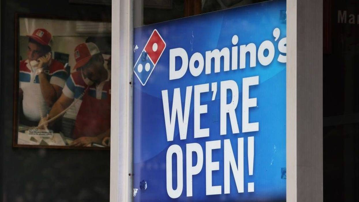 A "We're Open" sign is displayed on a window at a Domino's on August 19, 2020 in Brooklyn, New York. Domino's made an announcement on Tuesday that it is seeking to fill 20,000 positions at its corporate and franchise stores nationwide.