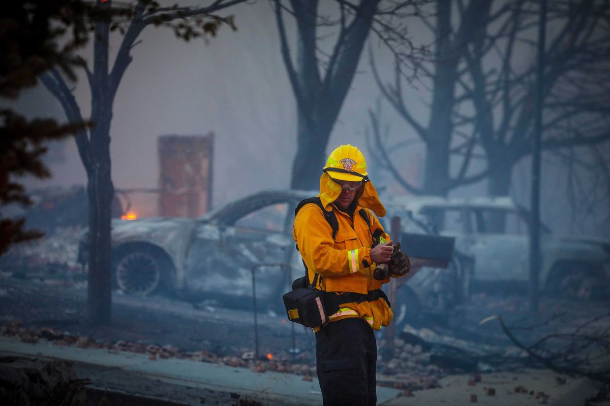 A West Metro firefighter takes in the damage after a fast moving wildfire swept through the area in the Centennial Heights neighborhood of Louisville, Colorado on December 30, 2021.