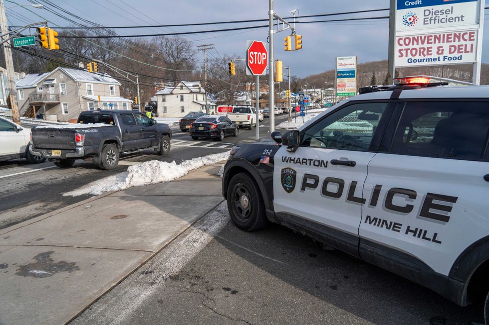A Wharton Police officer helps direct traffic on local roads as a sinkhole closes Interstate 80 eastbound near Exit 34 in Wharton on Monday, Feb. 10, 2025