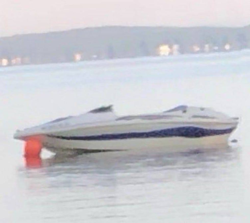 A white boat with a blue stripe