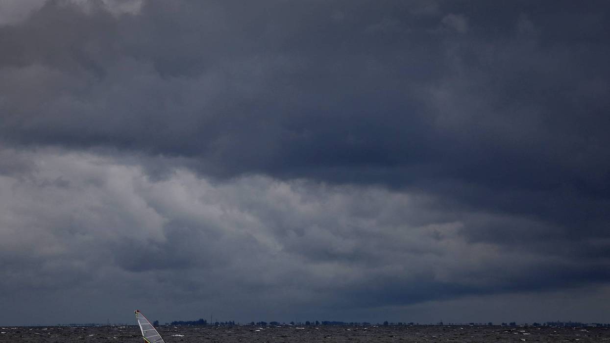 A windsurfer cruises through the water as clouds from the approaching Hurricane Ian darken the sky on Sept. 27, 2022, in St Petersburg, Florida. Hurricane Ian is expected to make landfall in the Tampa Bay area Wednesday night into early Thursday morning.