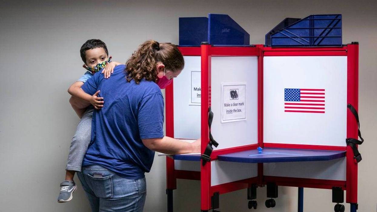 A woman casts her ballot for the 2020 presidential election at an early voting location on October 1, 2020 in Alexandria, Virginia. Virginia's early voting program for the November 3 national election began September 18 and continues through October 31.