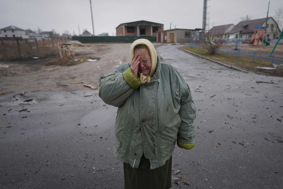 A woman cries outside houses damaged by a Russian airstrike, according to locals, in Gorenka, outside the capital Kyiv, Ukraine, Wednesday, March 2, 2022