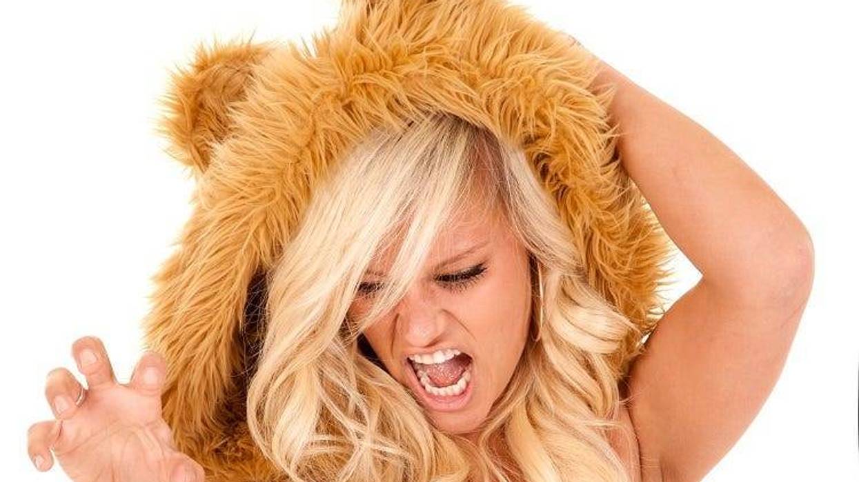 A woman dressed like a lion with her hand like claws.